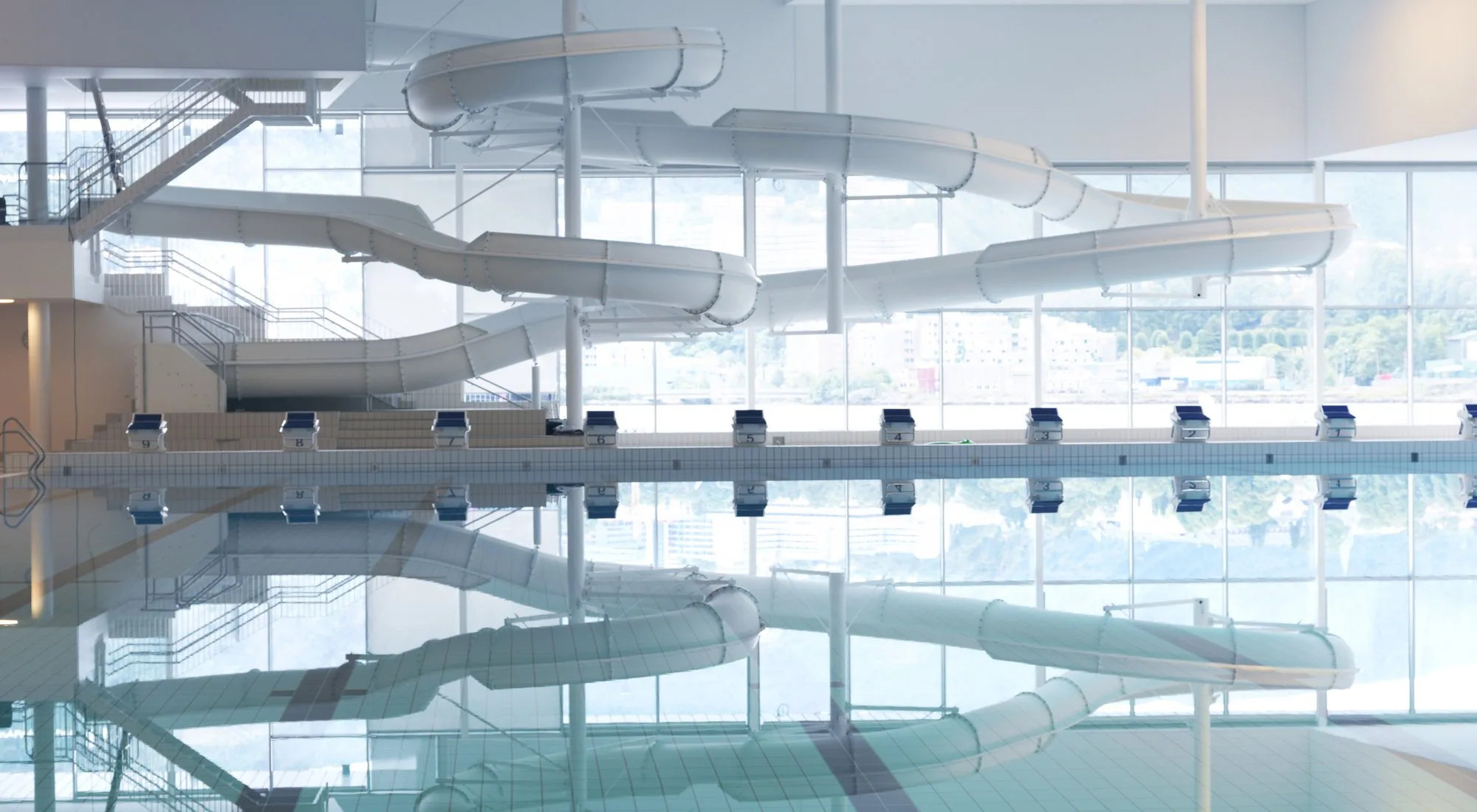 Indoor swimming pool with water slides reflected in the water