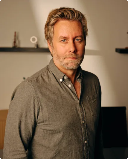 Man with blonde hair wearing dark gray button-up shirt