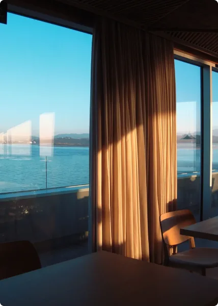 Hotel room with curtains and a window facing the fjord